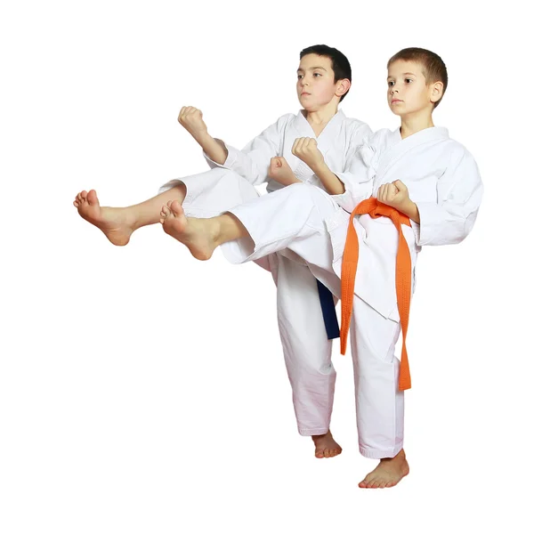 Спортсмены мальчики тренируются бить ногами на белом фоне — стоковое фото