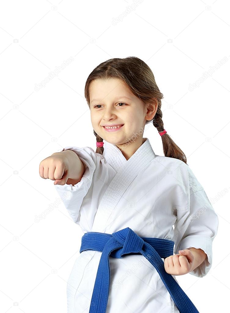 Cheerful girl with a blue belt beat a blow hand