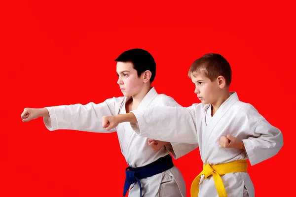 Blows arms in perform athletes  with blue and yellow belt — Stock Photo, Image