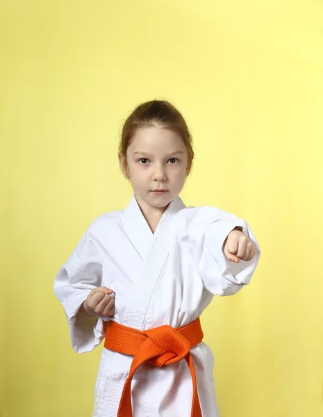 Im Kimono Mädchen auf gelbem Hintergrund schlägt linke Hand — Stockfoto