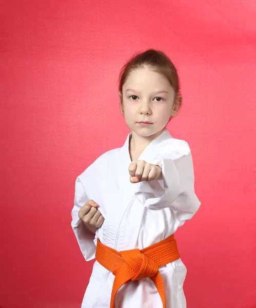 Girl on a red background is beat blow hand — Stock Photo, Image