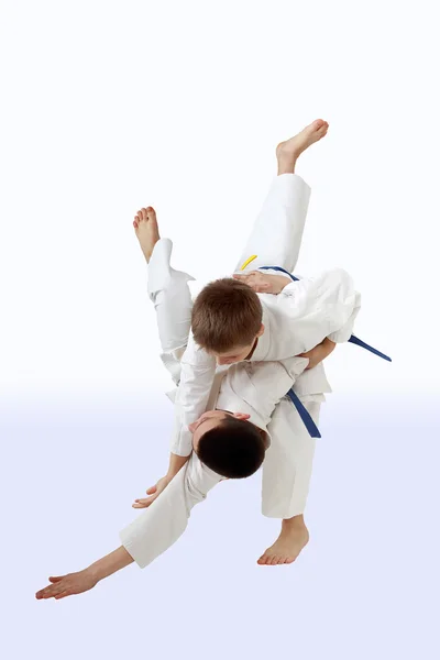 Barn i kimono tränar höga kast — Stockfoto