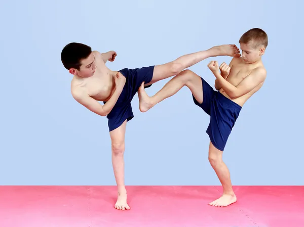 Los chicos en pantalones cortos están golpeando golpes patadas —  Fotos de Stock