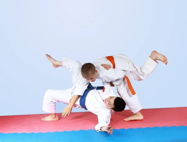 Sportsman with an orange belt threw athlete with a blue belt — Stock Photo, Image