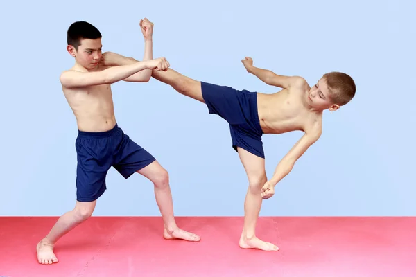 Спортсмены тренируются в шортах удары руками и ногами — стоковое фото
