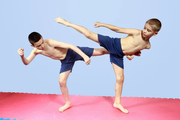 Удары ногами тренируют двух спортсменов в шортах — стоковое фото