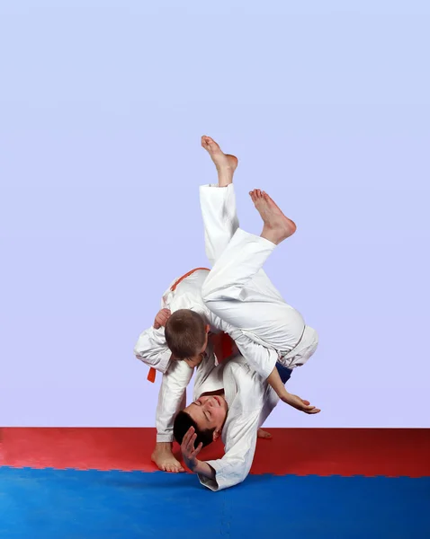 Throws through  the thigh  in the performance of an athlete with an orange belt — Stok fotoğraf