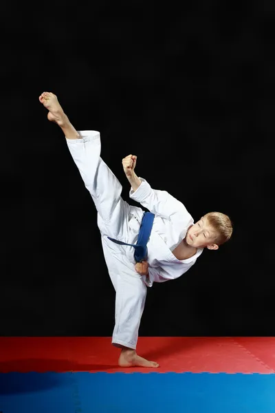 Circular kick leg an athlete is beating  with a blue belt — Stock Photo, Image