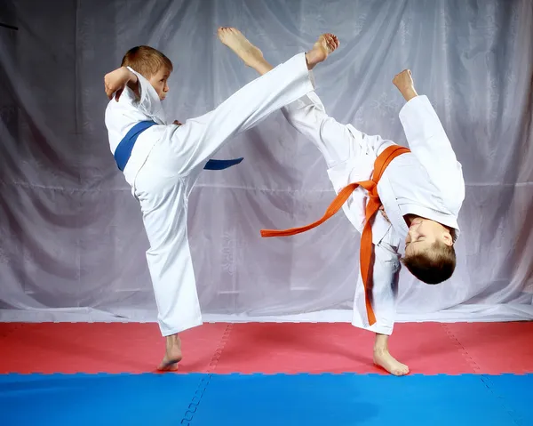 Удары ногами, чтобы встретиться друг с другом бьют спортсменов в karategi — стоковое фото