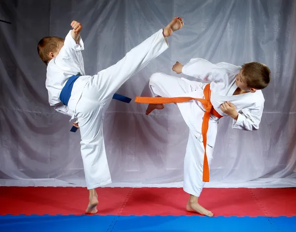 Sportsmen are training blows legs on the mat — Stock Photo, Image