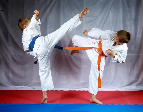 Les sportifs s'entraînent aux coups de pieds sur le tapis — Photo