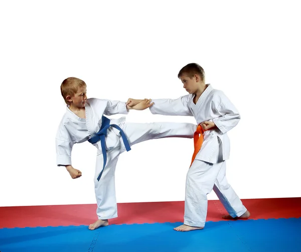 Kicking against blow hand is performing sportsman with a blue belt — Stock Photo, Image