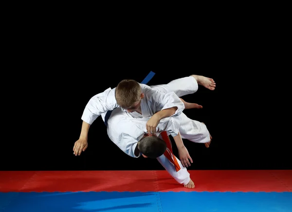 Dos jóvenes atletas en la fuerte caída realizan lanzamiento de judo — Foto de Stock