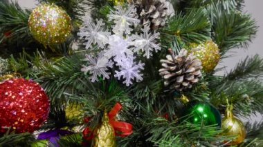 Açık arkaplanda, Noel oyuncakları yeşil bir Noel ağacında ve hediyeler yavaş çekimde.