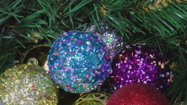 Разноцветные Игрушки Рождественские Елки Окружении Ветвей Елки Движении — стоковое видео