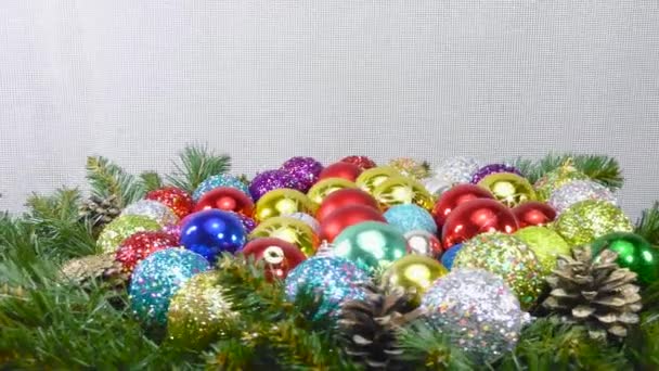 许多五彩缤纷的圣诞球夹在圣诞树枝头和圆锥之间 — 图库视频影像