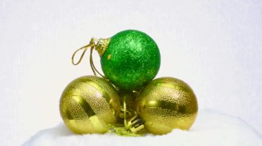Yeşil top ve üç top sarı top beyaz bir yüzey ve açık bir zemin üzerinde dönerler.