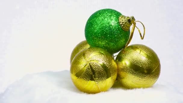 緑色のボールと黄色のボールの3つのボールは白い表面に回転します — ストック動画