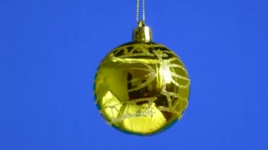 Mavi bir arka planda altın bir top dönüyor.