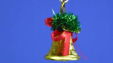 Mavi bir arka planda dönen altın bir Noel çanı