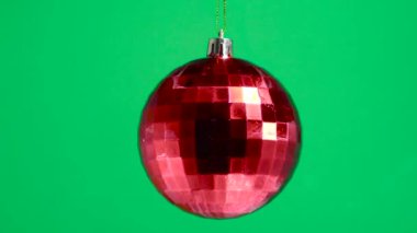 Kırmızı kareli bir top yeşil bir arkaplanda dönüyor