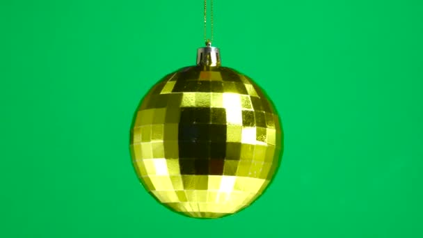 Golden Checkered Ball Spinning Green Plain Background — Stock Video