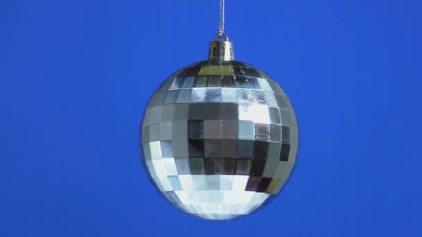 一只银色的圣诞球在蓝色的平原背景上旋转着 — 图库视频影像