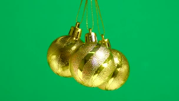 Palline Natale Oro Stanno Girando Uno Sfondo Verde Pianura — Video Stock