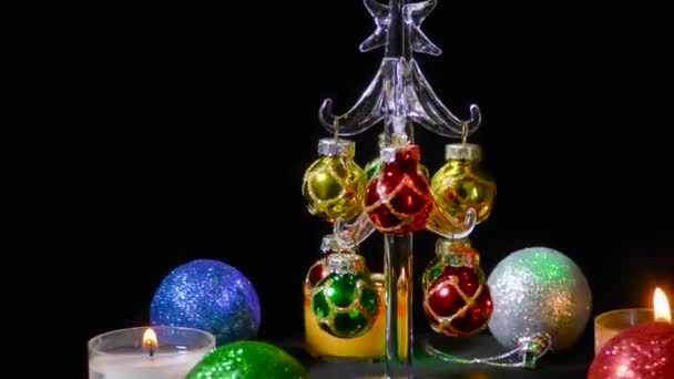 Kleine Kerstboom Draait Omringd Door Veelkleurige Kerstkaarsen Ballen — Stockvideo