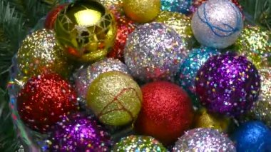 Cam bir vazoda, parıltılı çok renkli toplar Noel ağacı dalları ve bir salgı bezinin üzerinde dönüyorlar.