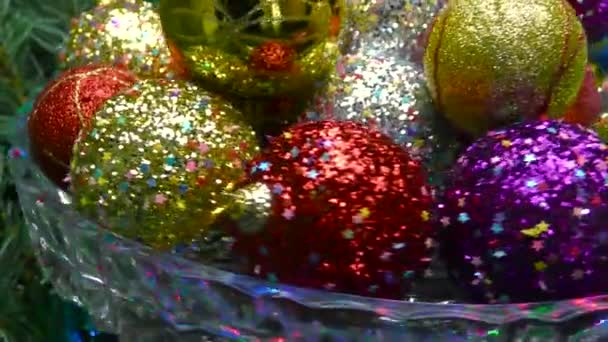 ガラスの花瓶のクローズアップパターンと輝きを持つ多色のボールは クリスマスツリーの枝を回転させます — ストック動画