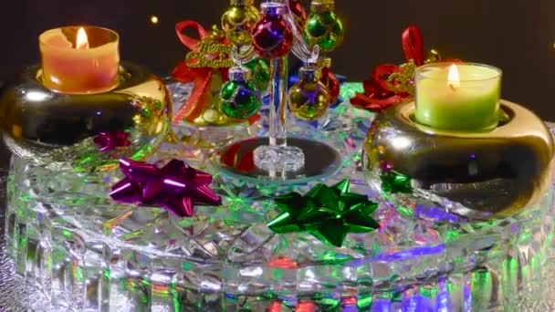 在一个闪烁着花纹的表面 一棵被圣诞钟声和小蜡烛环绕的小圣诞树 — 图库视频影像