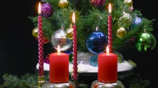 圣诞在燃烧的蜡烛后面摇曳着一棵用圣诞球装饰的大圣诞树 — 图库视频影像