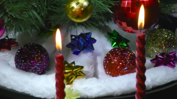 在燃烧着蜡烛的特写后 圣诞在白色毛毯上旋转着一棵装饰过的圣诞树 上面挂着玩具 — 图库视频影像