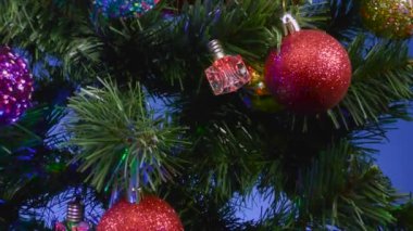Noel 'de mavi arka planda yakın plan toplar ve Noel ağacında çanlar