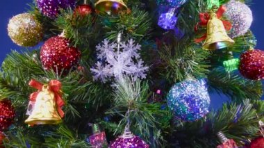 Mavi arka planda hareketli bir Noel ağacı çok renkli ışınlar ile süslenmiş.