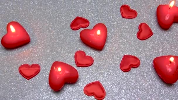Auf Einer Grauen Paillettenoberfläche Brennen Viele Kerzen Und Herzen — Stockvideo