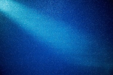 Mavi kumlu arka planda parlak mavi ışık demeti