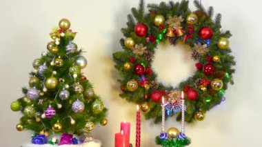 Christmas in motion burning multi-colored candles between a Christmas tree and a Christmas wreath