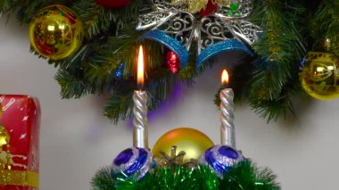 Close up of burning candles with balls on background of christmas wreath