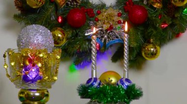 Christmas composition vase with ball and two candles on the background of a Christmas wreath