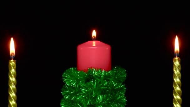 Red Candle Decorated Green Tinsel Rotates Two Golden Candles — Vídeos de Stock