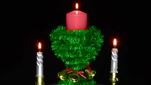 Red Burning Candle Decorated Green Tinsel Revolves Two Small Burning — Stockvideo