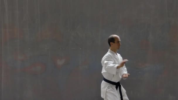 Young Sportsman Blue Belt Performs Formal Exercises Background Street Wall — Vídeos de Stock