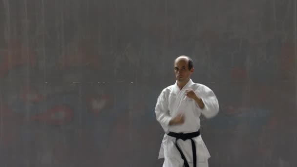 Young Sportsman Blue Belt Doing Formal Exercises Street Wall Background — Vídeo de Stock