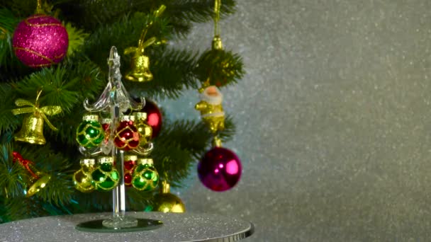 Small Christmas Tree Rotates Large Decorated Christmas Tree — Stock video
