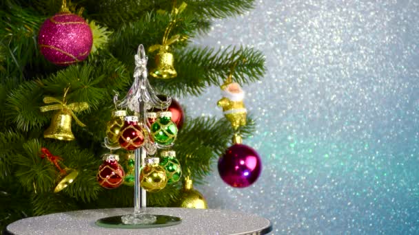 Small Christmas Tree Rotates Large Decorated Christmas Tree — Stock video