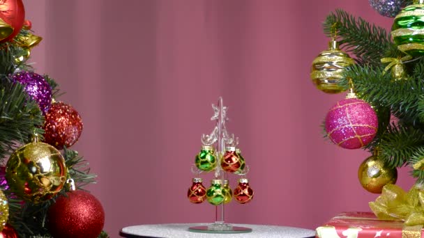Pink Background Small Christmas Tree Rotates Large Christmas Trees Decorated — Stockvideo
