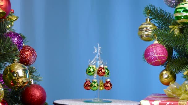 Blue Background Small Christmas Tree Rotates Large Christmas Trees Decorated — Vídeos de Stock