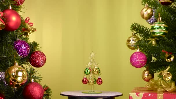 Yellow Background Small Christmas Tree Rotates Large Christmas Trees Decorated — Vídeos de Stock